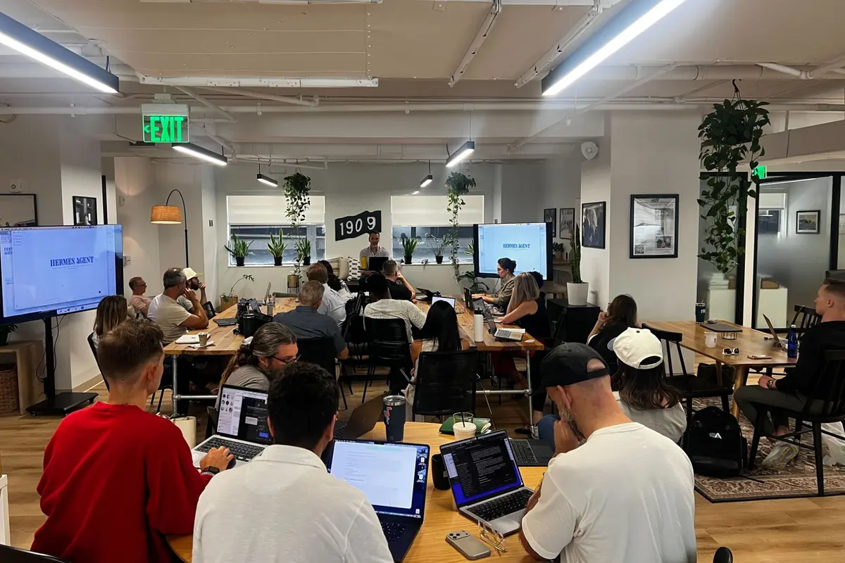 A full room at 1909 in West Palm Beach, laptops open, with Hermes Agent on the screens and Brian Schmitt leading the session